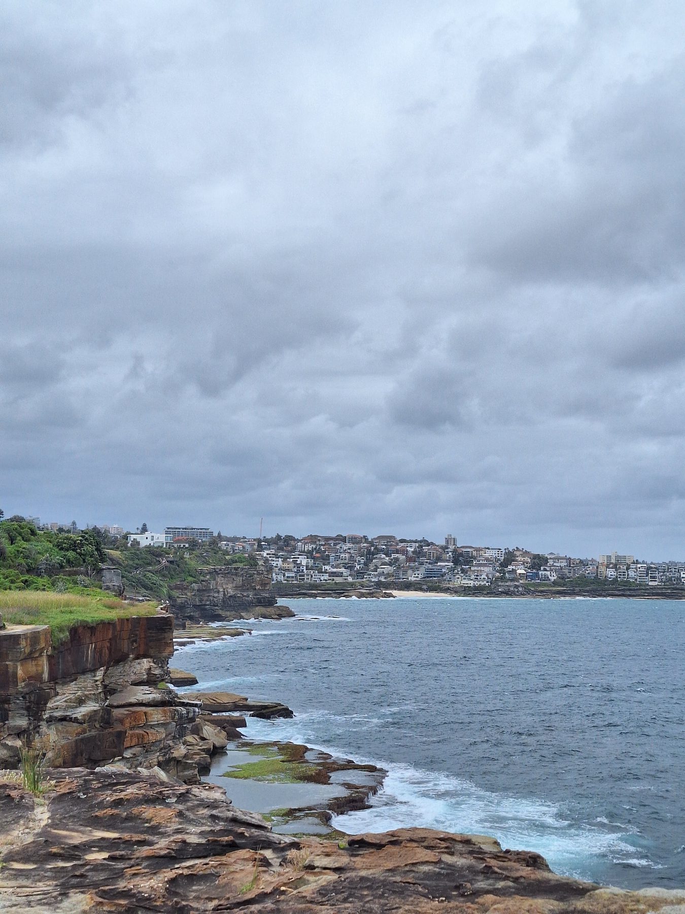 Flat sandstone ledges and surf below the clifftop path on Sydney's eastern beaches