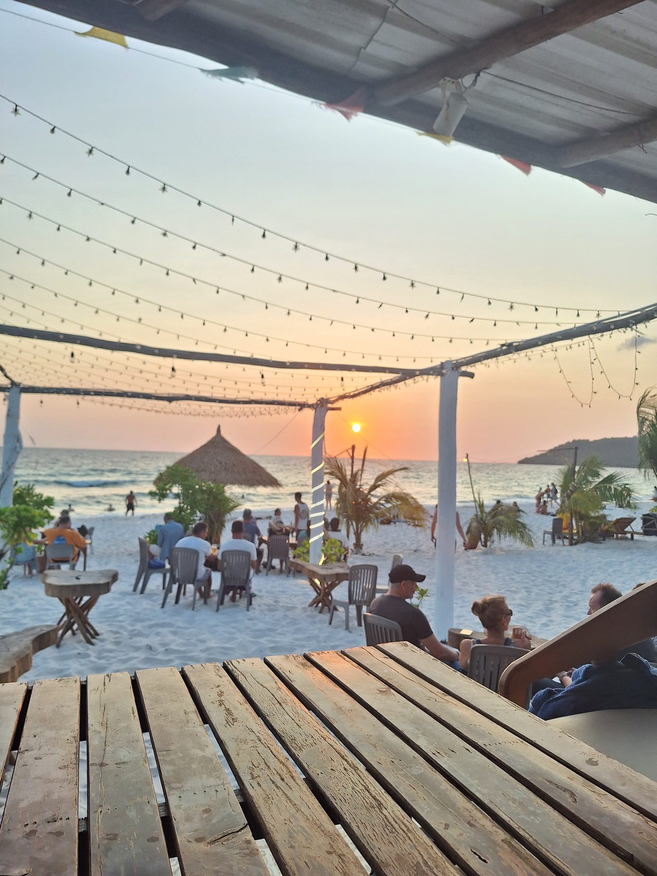 A beach bar strung with lights at sunset on Koh Rong, Cambodia