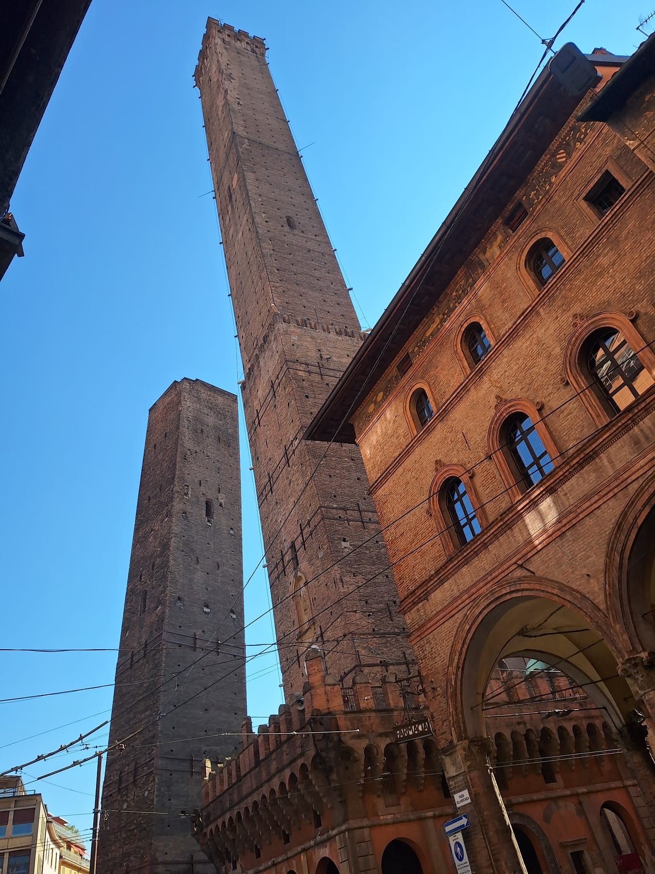 The two medieval brick towers of Bologna, Asinelli and the shorter leaning Garisenda, seen from the street below