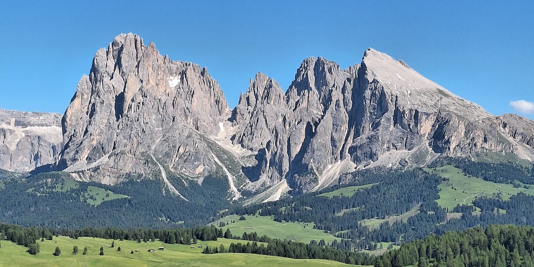 The jagged peaks of the Sassolungo above the green meadows of the Alpe di Siusi