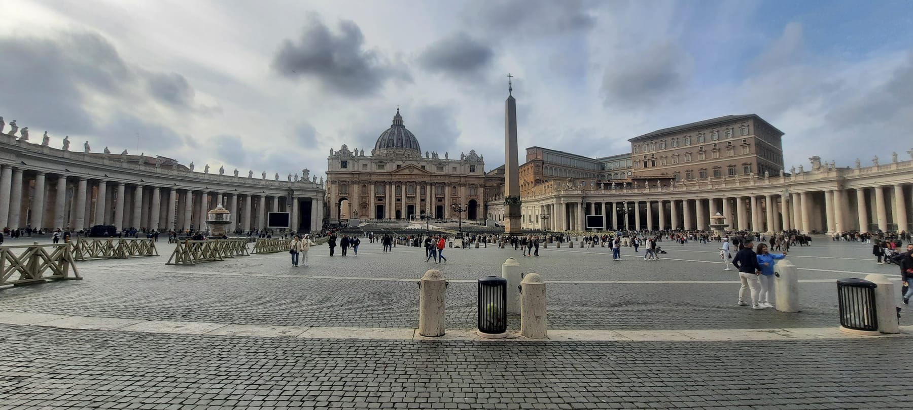 St Peter's Square with its curving colonnades, Egyptian obelisk and the basilica dome under a cloudy sky