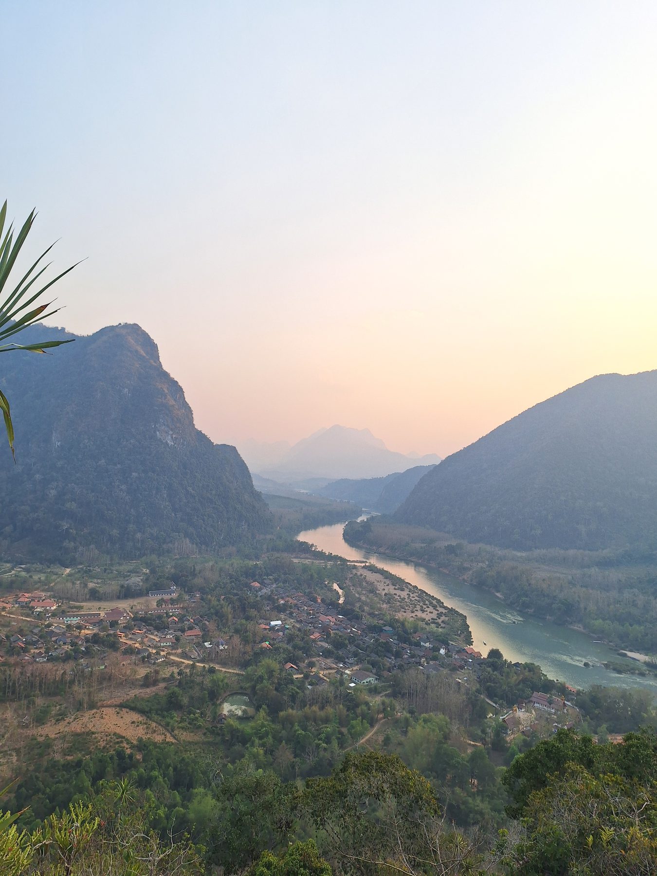 The Nam Ou river winding through a valley of forested mountains, seen from the viewpoint above Muang Ngoi
