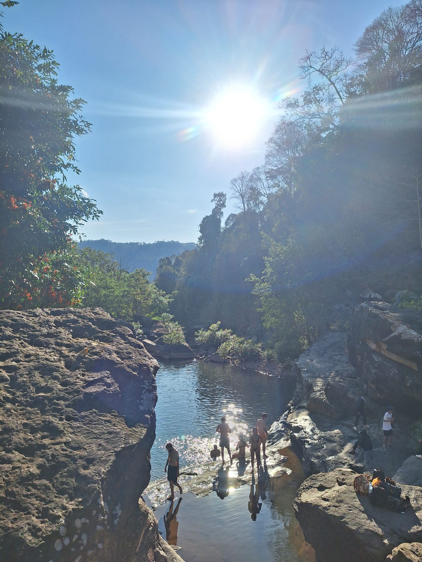 People swimming in a river pool among rocks on the Thakhek loop