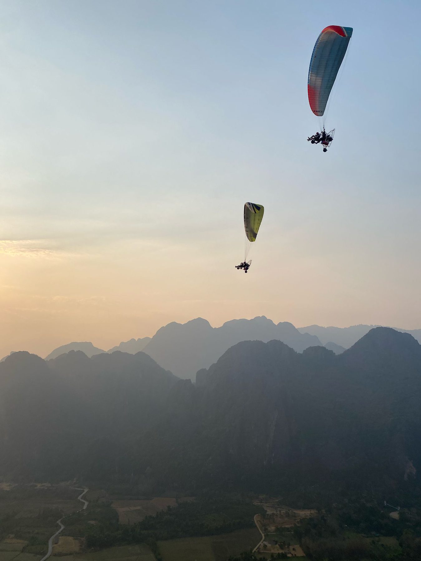 A paraglider above karst peaks at sunset, Vang Vieng, Laos
