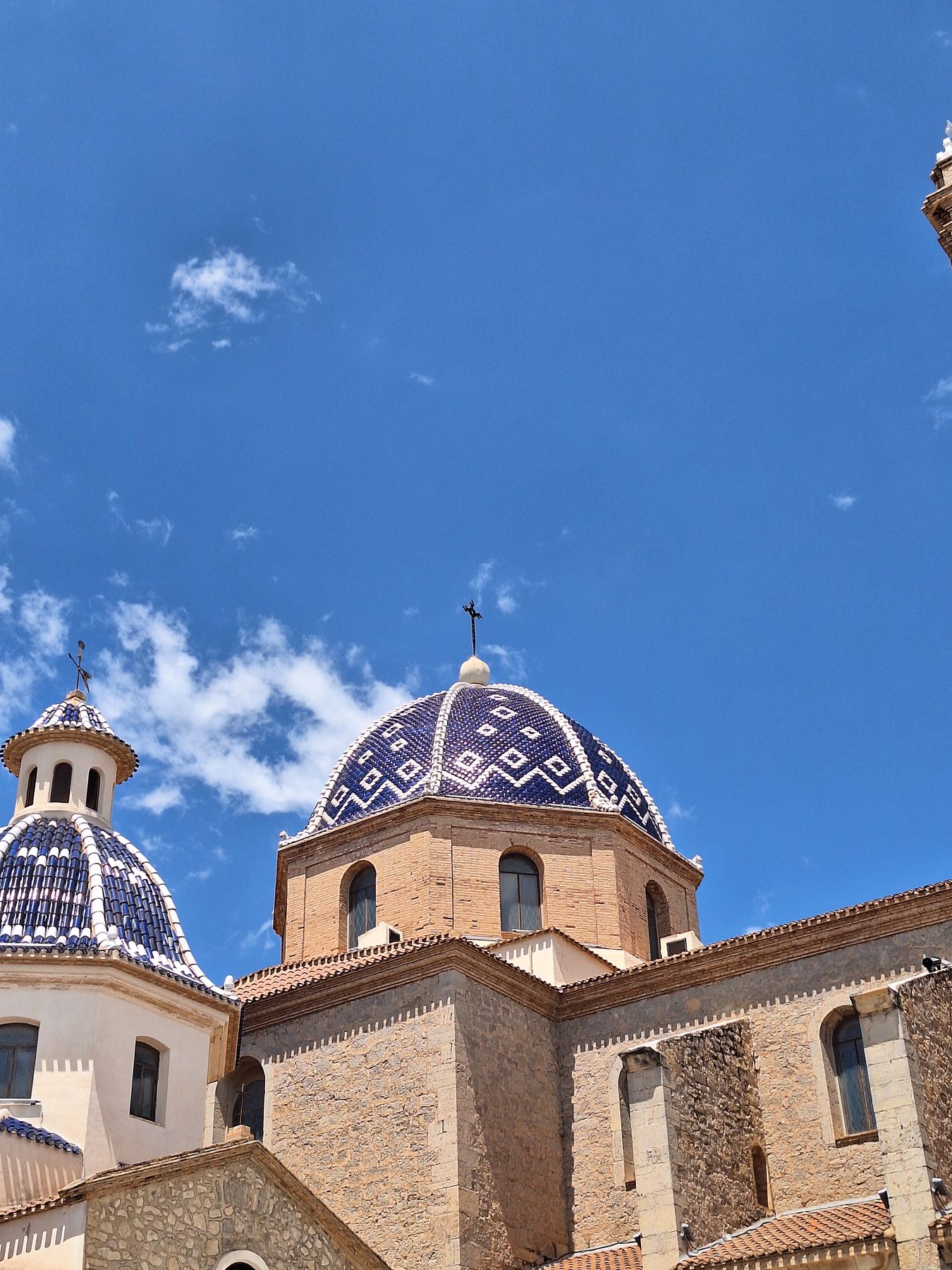 The blue and white tiled dome of the church at Altea against a bright sky