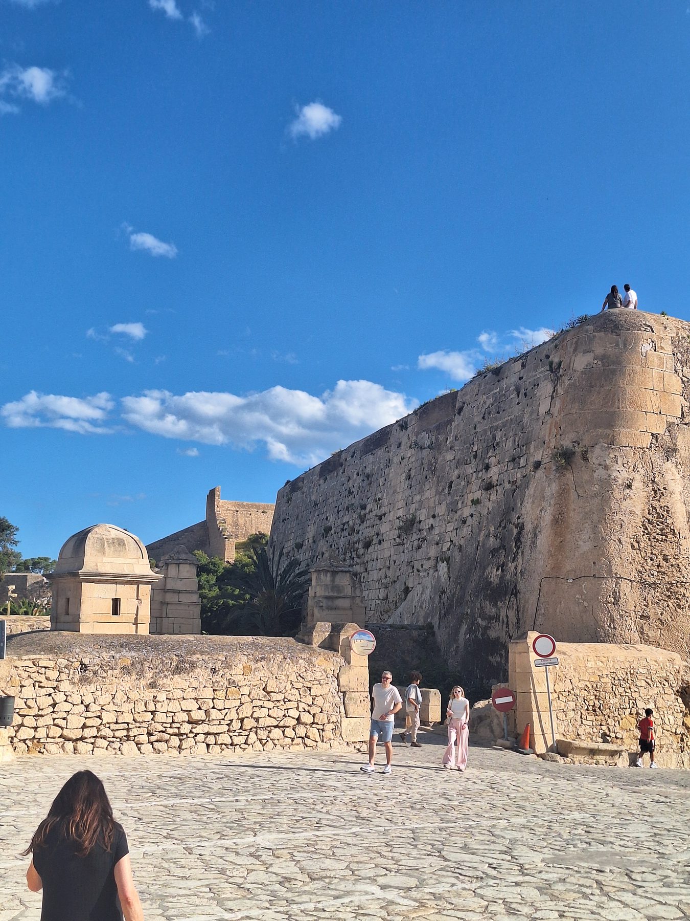 The stone walls and bastions of Santa Bárbara castle above Alicante against a blue sky