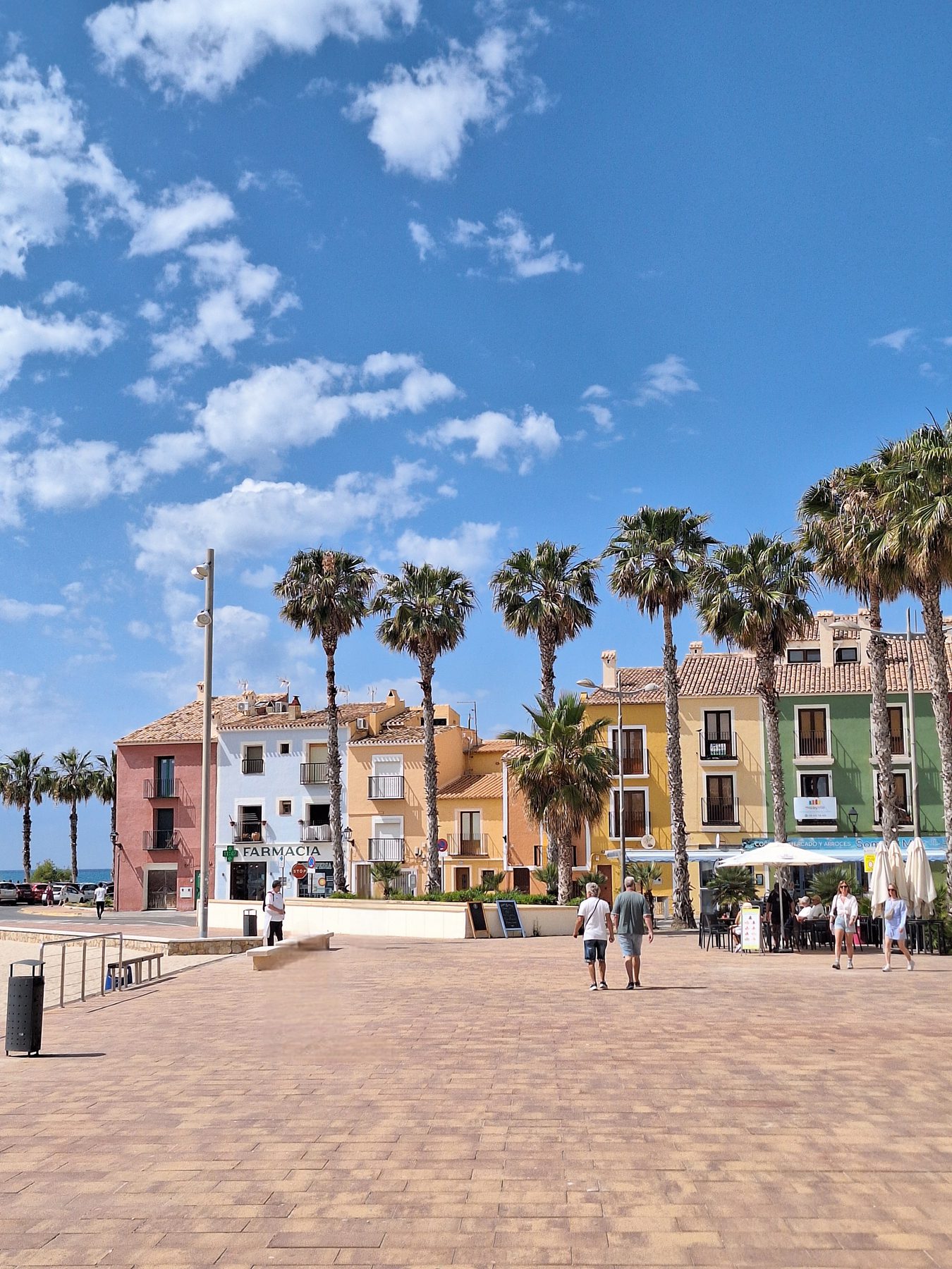 Les cases de colors, the brightly painted fishermen's houses of Villajoyosa, lining a plaza with palm trees
