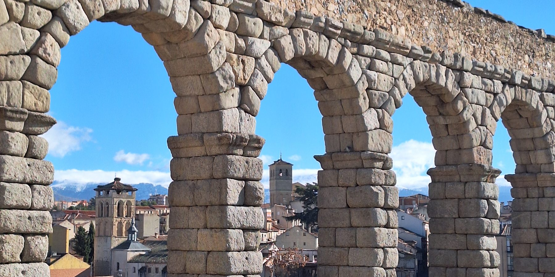 The arches of the Roman aqueduct at Segovia with the old town behind