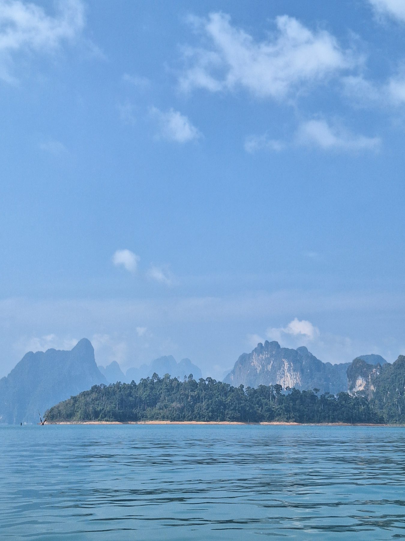 Morning light on the karsts and still water of Cheow Lan Lake, Thailand