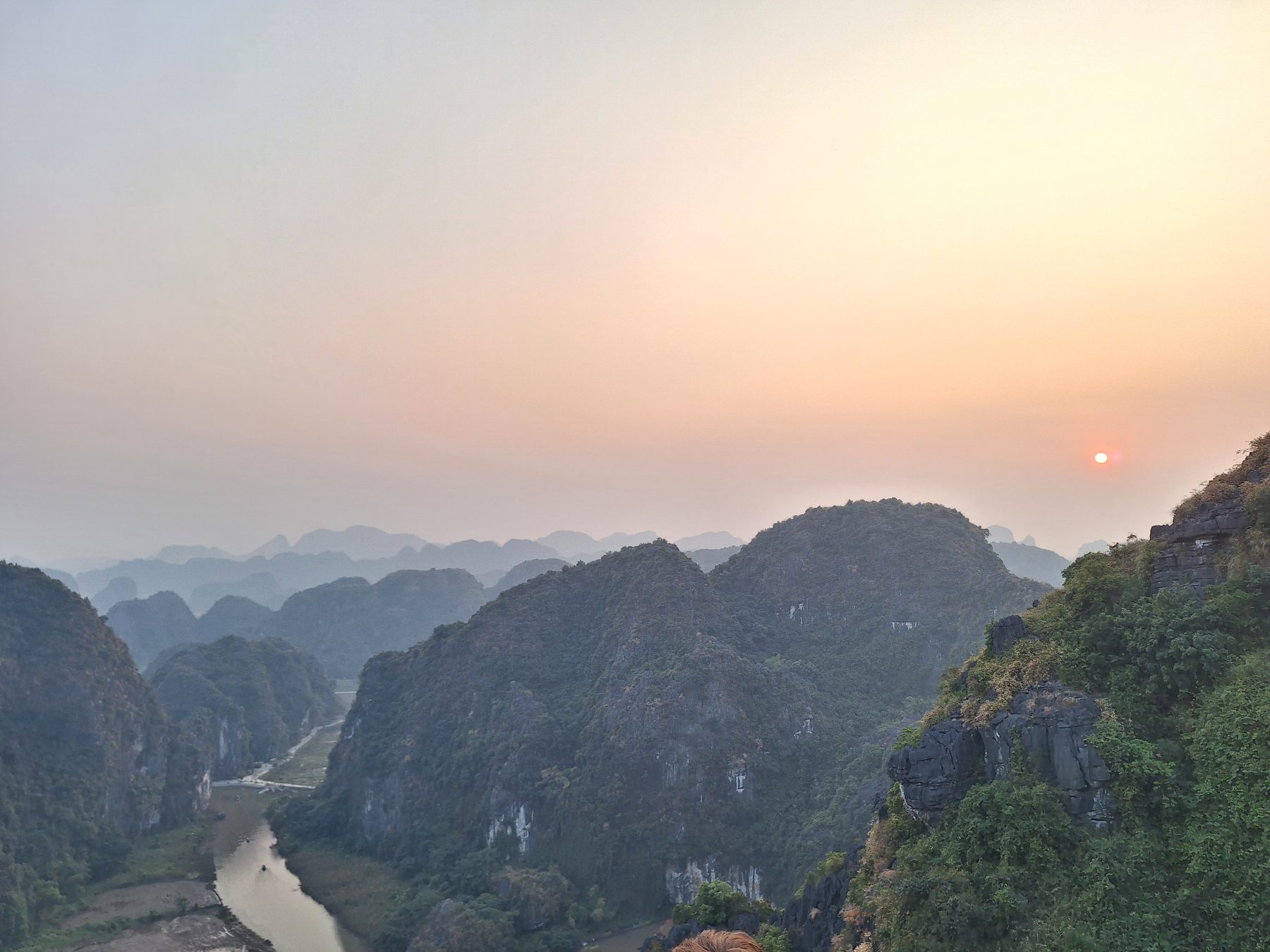 Karst peaks and a river at sunset in the Ninh Binh valley, Vietnam
