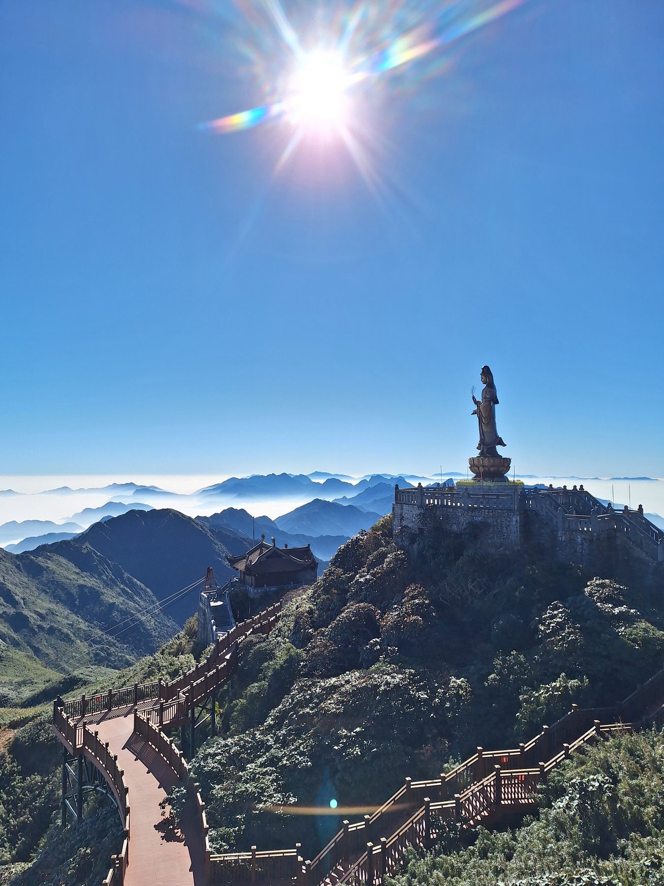 A large bronze Buddha statue on a peak above a sea of cloud at Fansipan, Vietnam