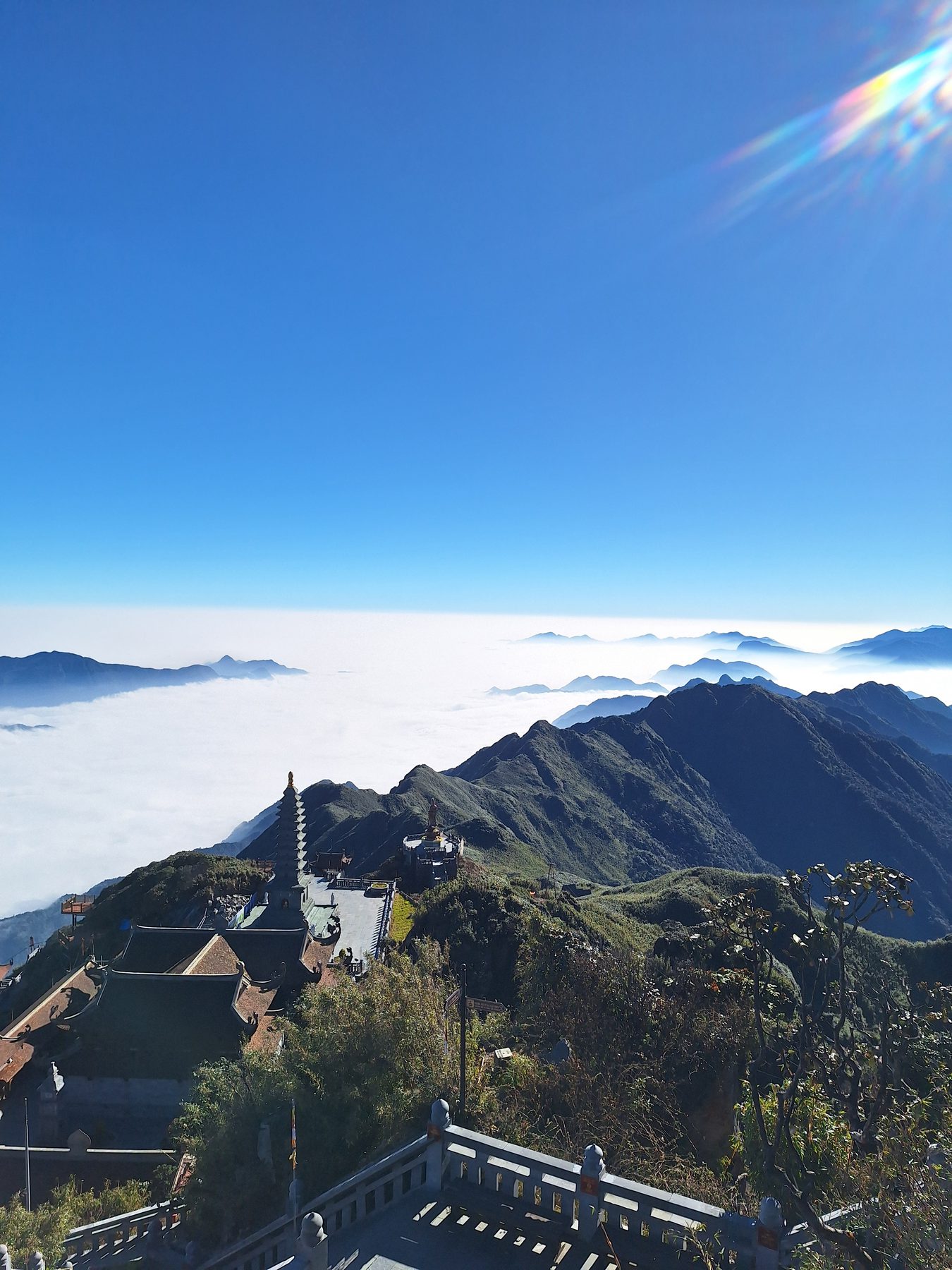 Tiered temple roofs of the Fansipan summit complex with mountain ridges and cloud below